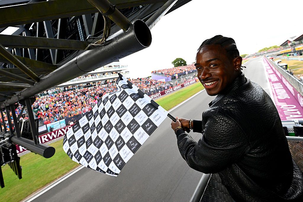 NORTHAMPTON, ENGLAND - JULY 06: Damson Idris, co-star of the Formula One based movie, F1 waves the chequered flag during the F1 Grand Prix of Great Britain at Silverstone Circuit on July 06, 2025 in Northampton, England. (Photo by Mark Sutton - Formula 1/Formula 1 via Getty Images)