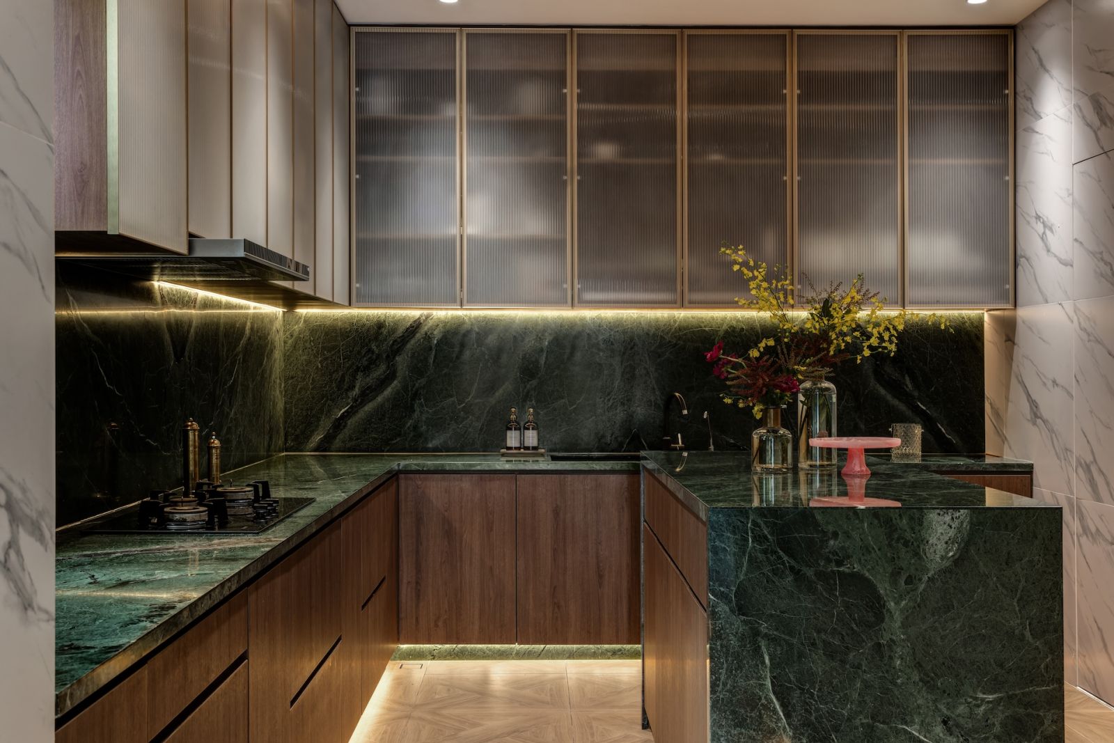The kitchen in a Hong Kong home grounded by emerald marble, glass and metal