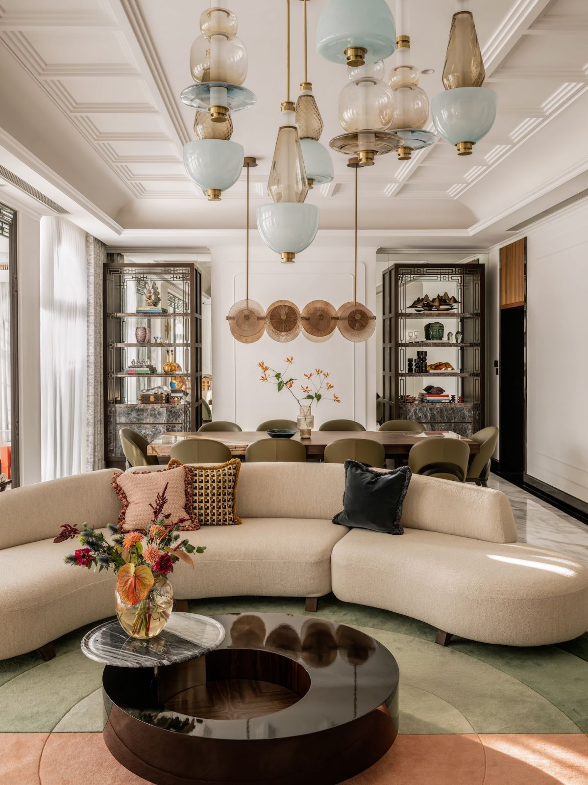 The living room in a Hong Kong multigenerational home designed by Liquid Interiors, featuring lighting fixtures by Gabriel Scott