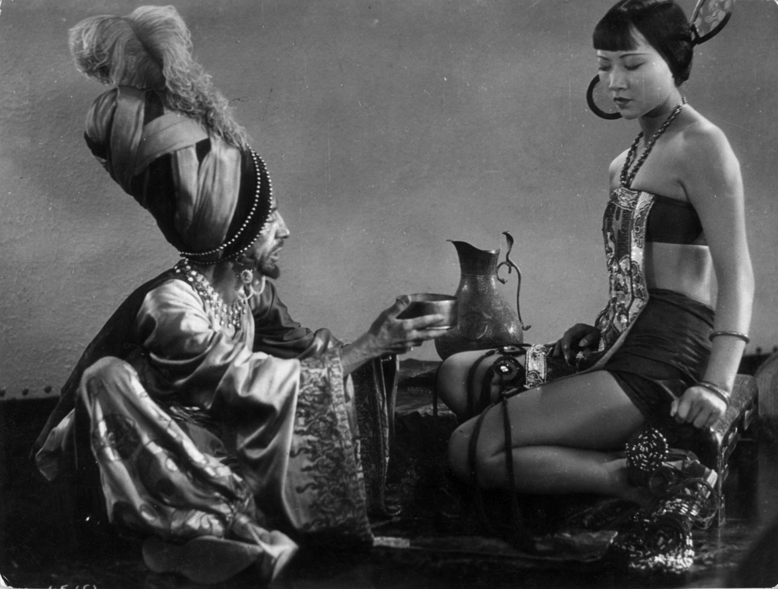 1924: The evil associate played by Snitz Edwards discusses the Princess with Anna May Wong in 'The Theif Of Bagdad' a flamboyant silent film which borrows from the arabian nights tales. Directed by Raoul Walsh for Douglas Fairbank's studio. (Photo by General Photographic Agency/Getty Images)