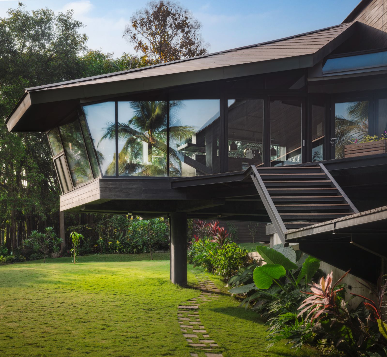 Minimally invasive foundation of stilts and concrete retaining walls protects the structure from moisture and capillary action