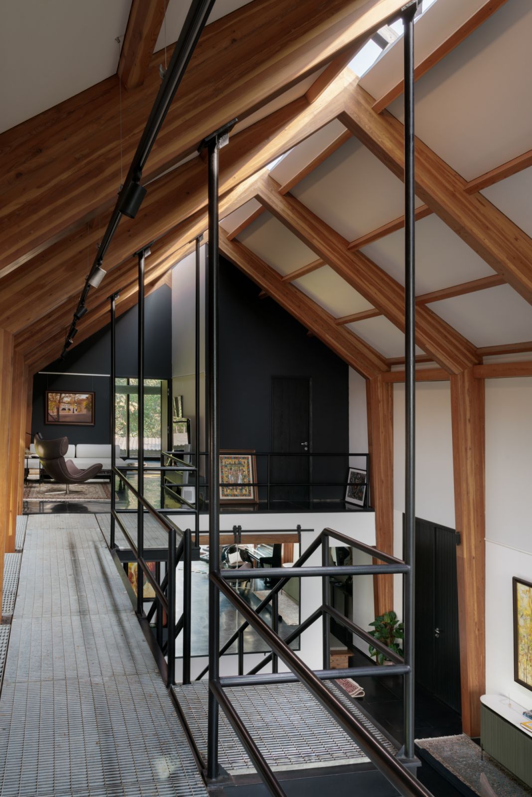 A black metal-clad staircase leads to the master bedroom on the mezzanine floor