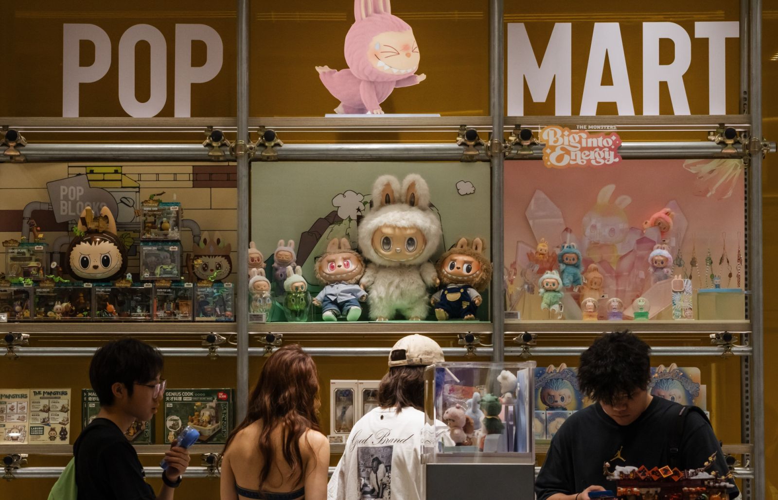 CHONGQING, CHINA - JUNE 16: Customers browse a POP MART display filled with Labubu characters and collectible figures from The Monsters series on June 16, 2025 in Chongqing, China. The Labubu IP has surged in popularity among China's Gen Z, with limited-edition drops, co-branded products, and immersive storefront experiences turning designer toys into a mainstream cultural phenomenon. (Photo by Cheng Xin/Getty Images)