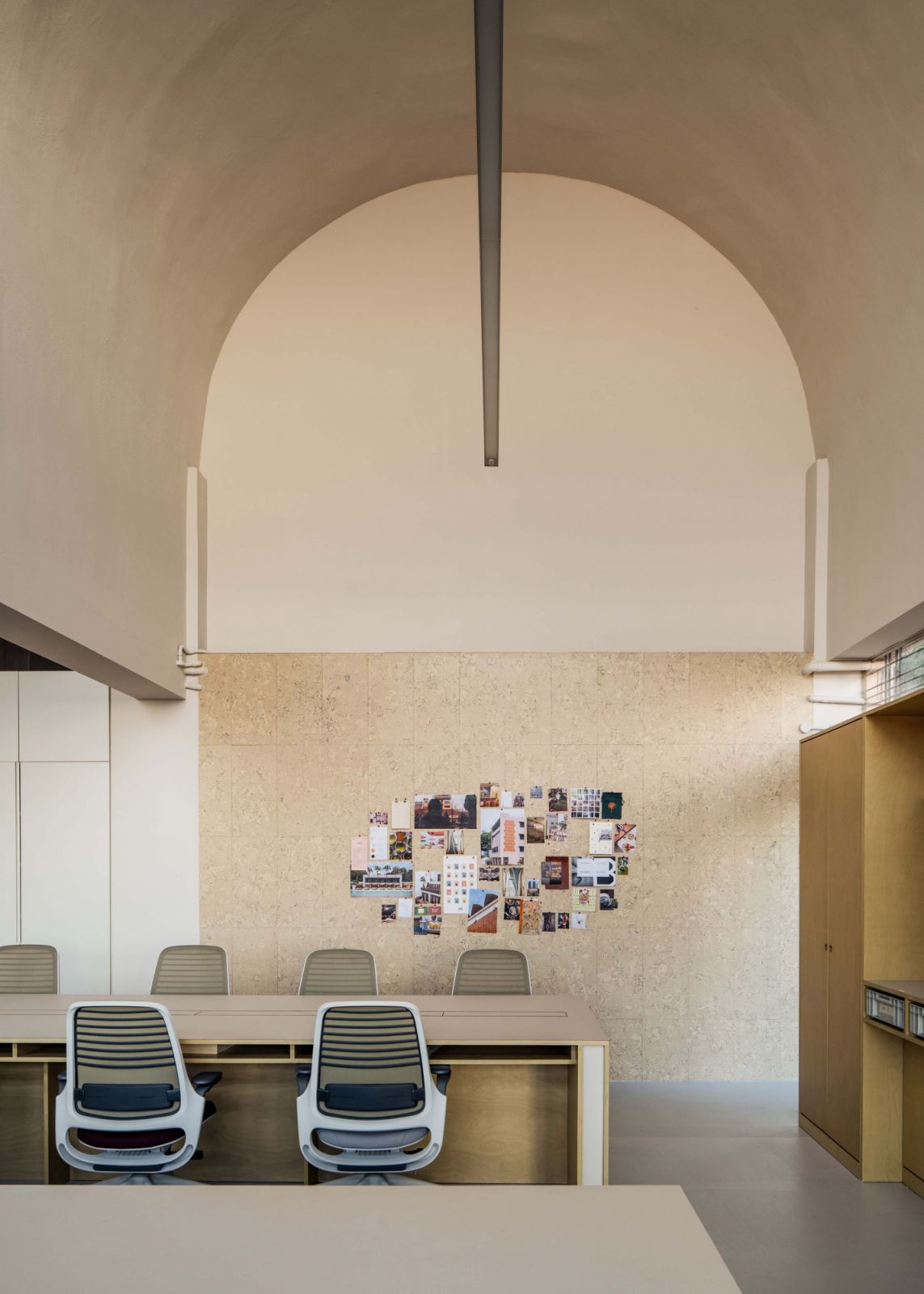 The original architecture’s barrel vaulted ceiling gives the office a distinctive character