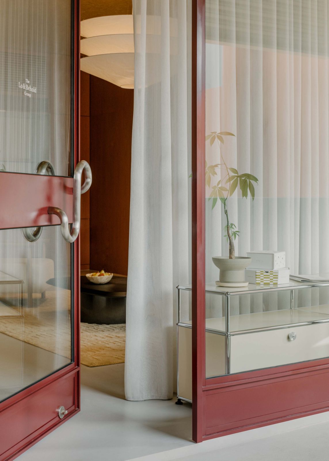 A custom door handle and USM Haller console at the entrance of the HQ at the Lo & Behold Group’s office