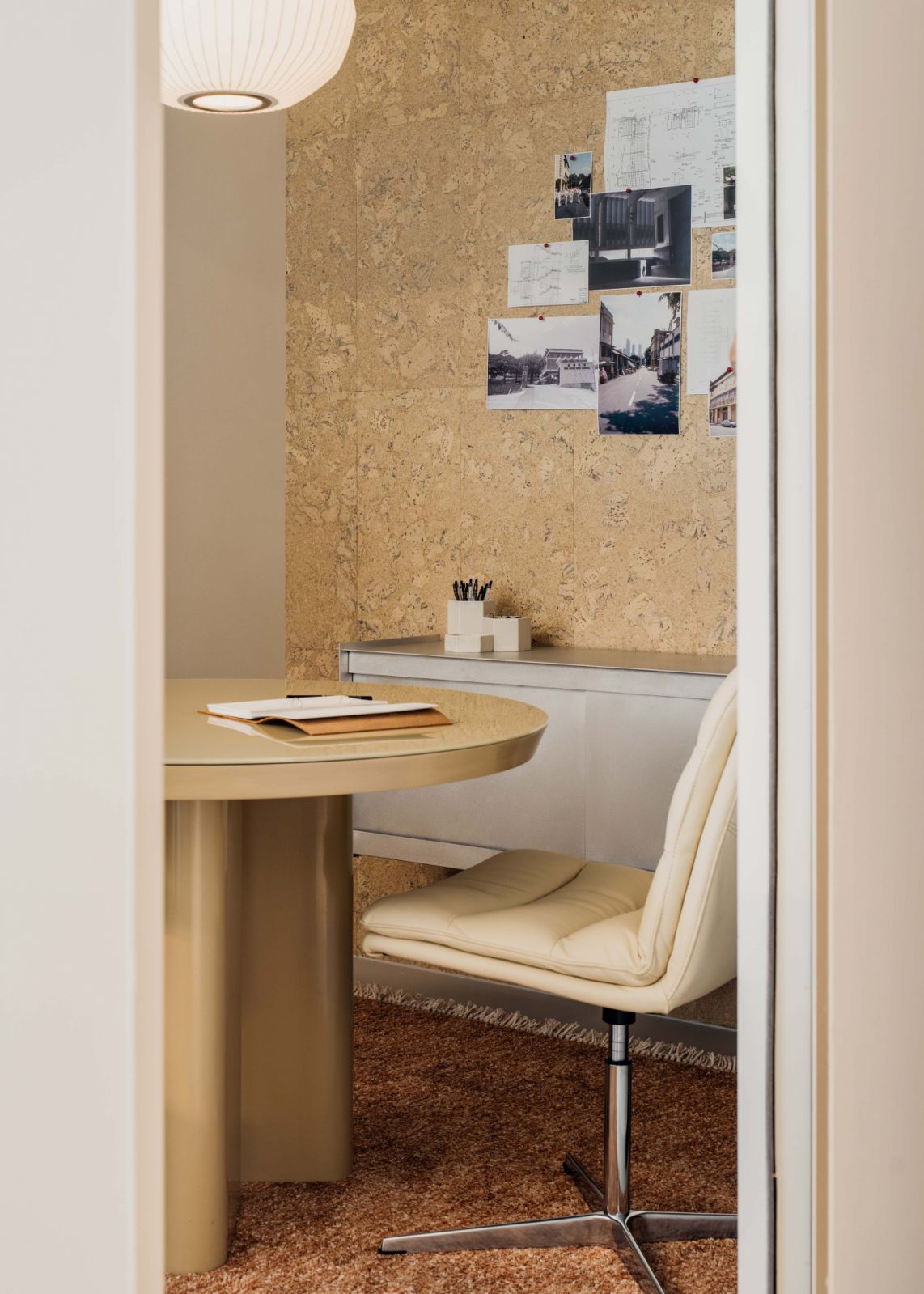 A light-filled c-suite office with a slim custom-designed table and Nelson Bubble pendant from Hay