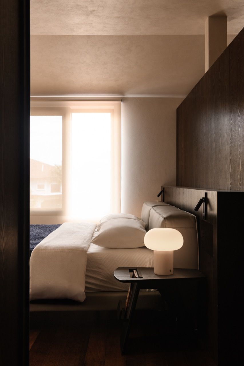 The master bedroom features darker walnut-stained Senply timber veneer to create what Lim calls a bolder, more intimate atmosphere, contrasting with the natural tones used elsewhere