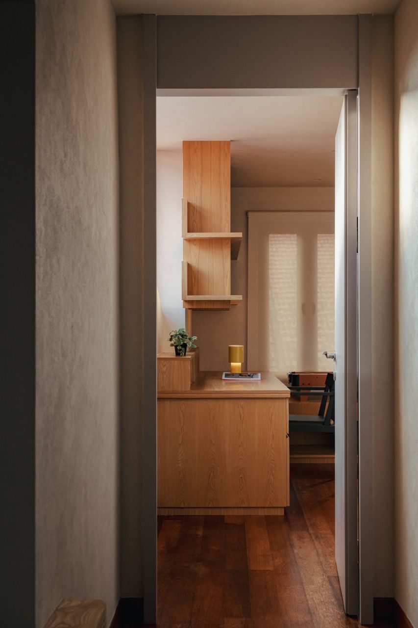 A glimpse into the master bedroom’s home office area, where the central column was used to anchor a low dividing wall that separates the sleeping area from the workspace