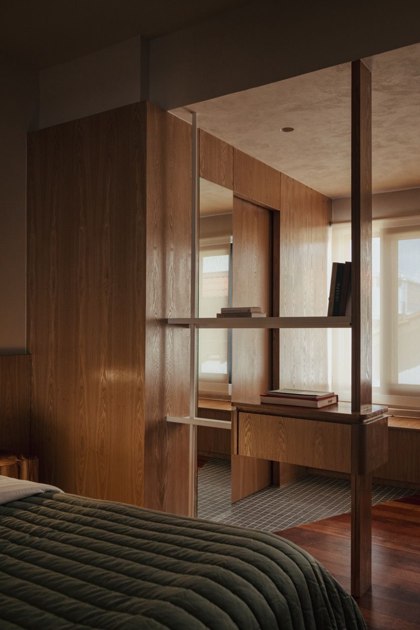 The master bedroom’s custom storage solution integrates seamlessly with the room's architecture, using the problematic central column as an anchor point for functional design