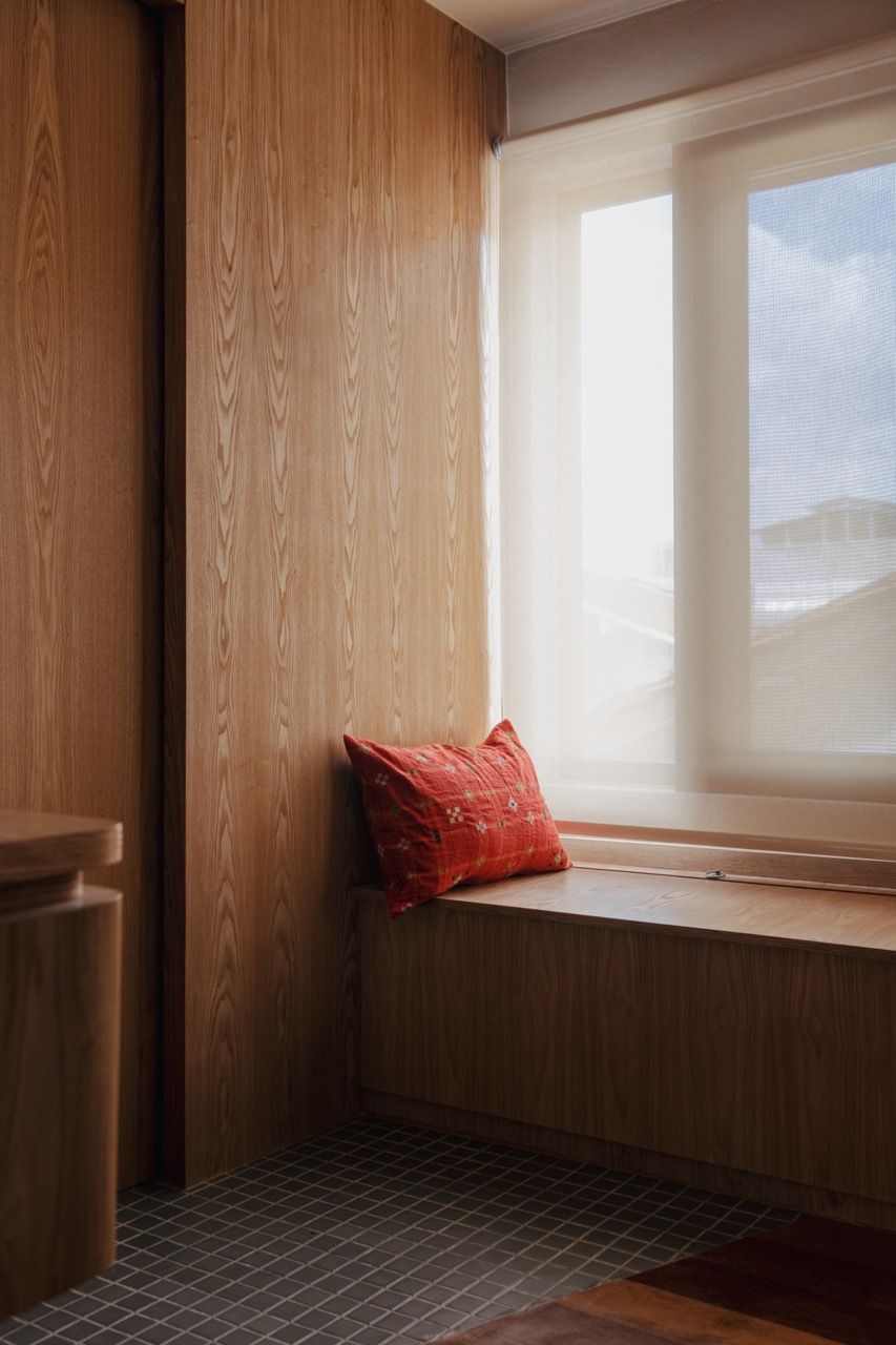 Built-in window seating with Senply timber veneer creates a cosy reading nook, demonstrating how the design embraces the home’s original architectural features