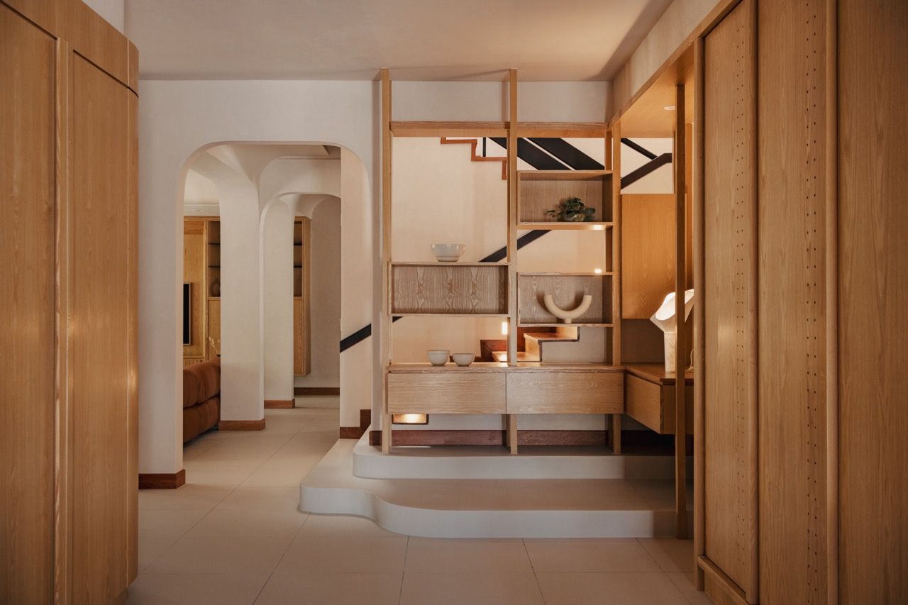 The staircase area with custom Senply timber display shelving, showing the integration of storage and circulation spaces
