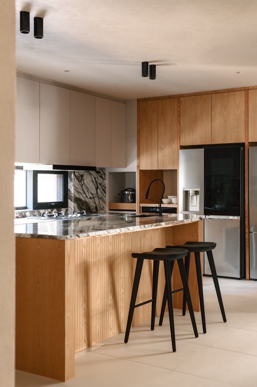 The new kitchen area, built where the previous owner’s backyard used to be, featuring the black sintered stone countertops by Nex and the timber veneer cabinetry