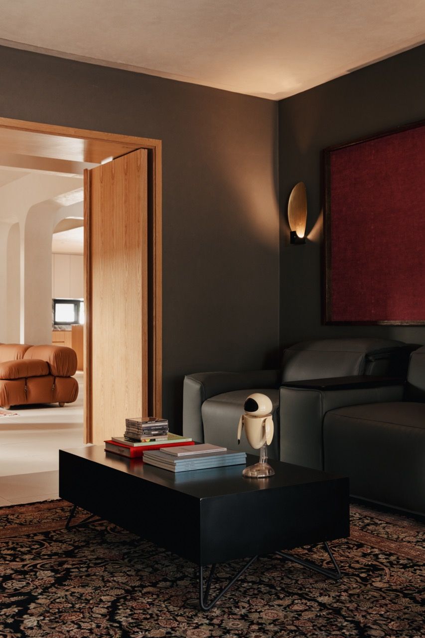 The theatre room features King Living reclining sofas and custom cabinetry that serves dual purposes - concealed storage from the entrance side and an acoustic partition from inside