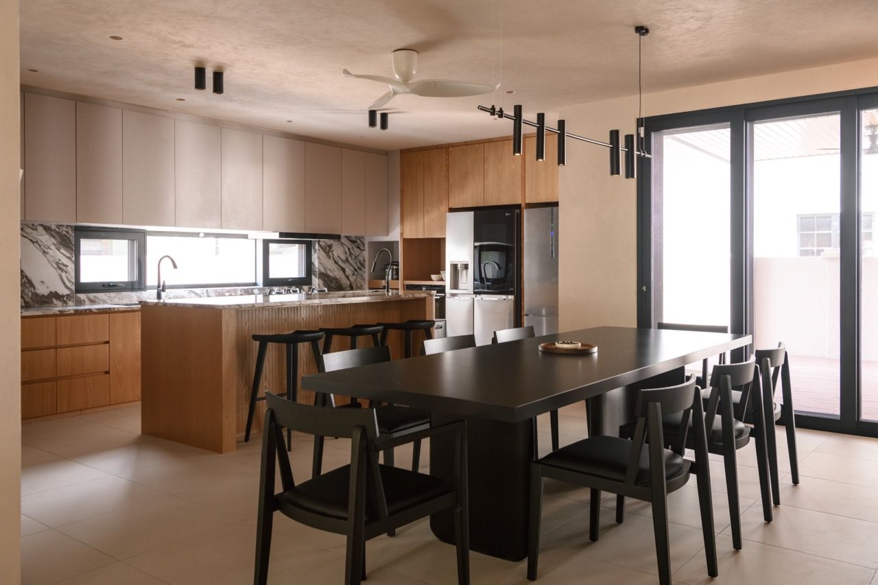 Kitchen overview showing the dramatic veined stone backsplash and the integration of the new addition with the original house structure