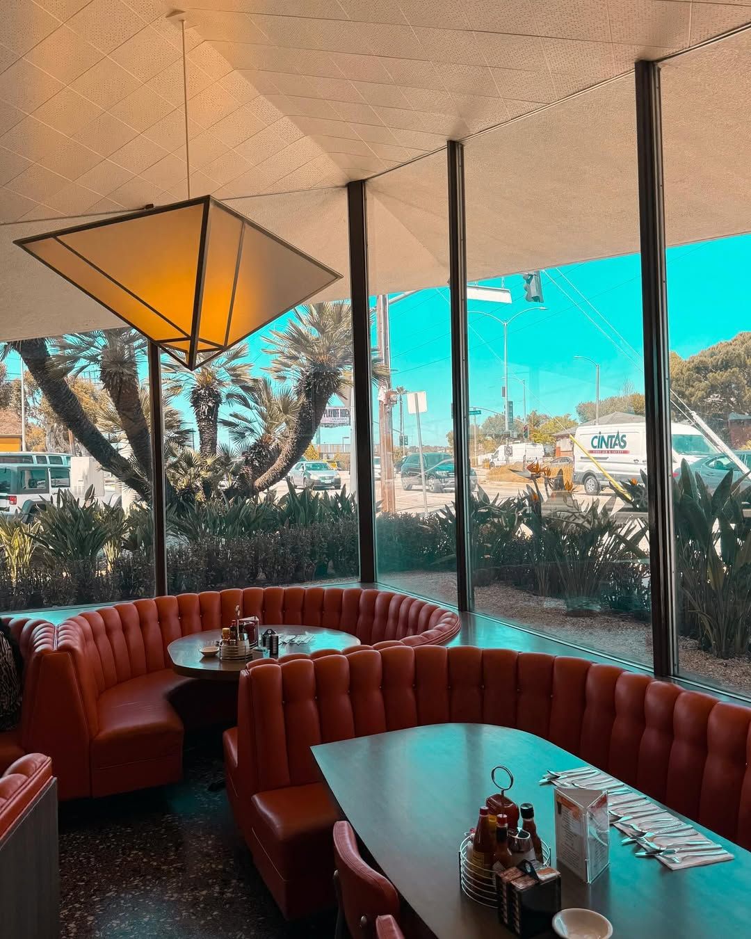 The interiors feature floor-to-ceiling glass panels supported by slender vertical steel mullions (Photo: Instagram / @merchmotel)