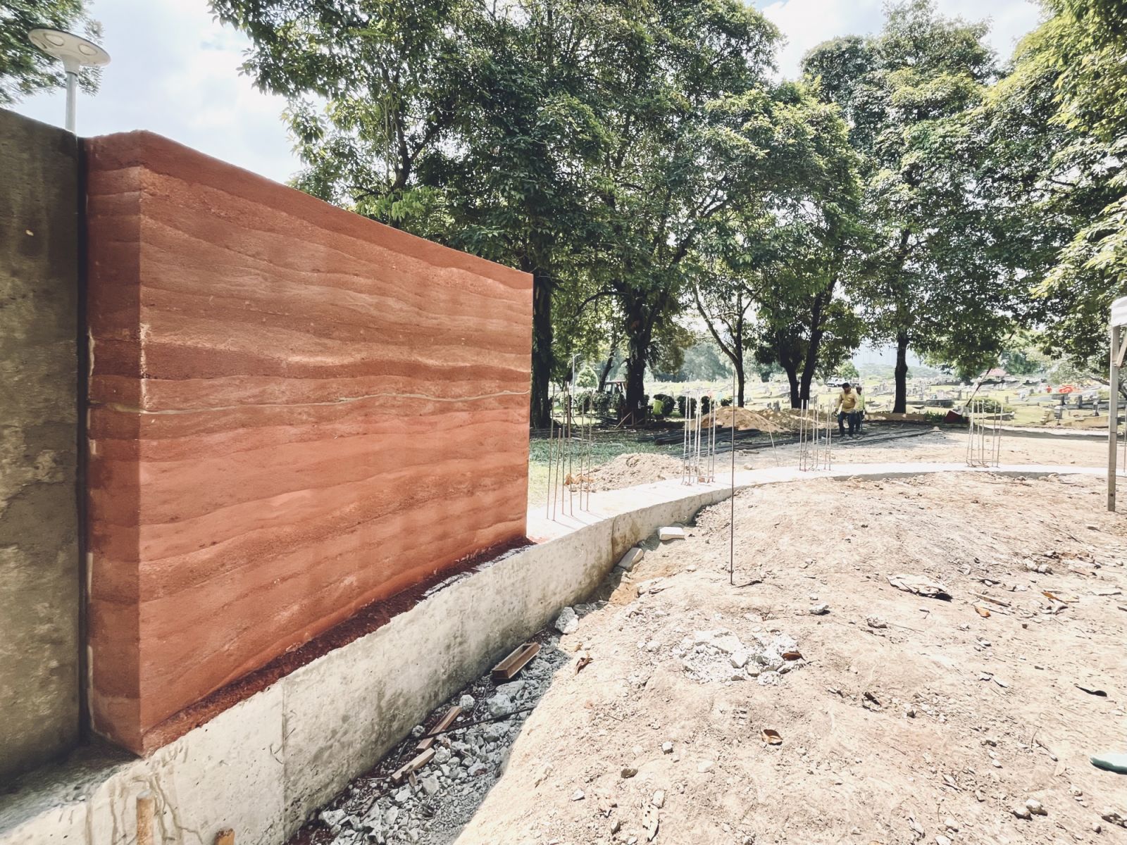 Early construction detail of the rammed earth wall technique, showing the layered earth construction method that creates the distinctive horizontal striations in the finished surface