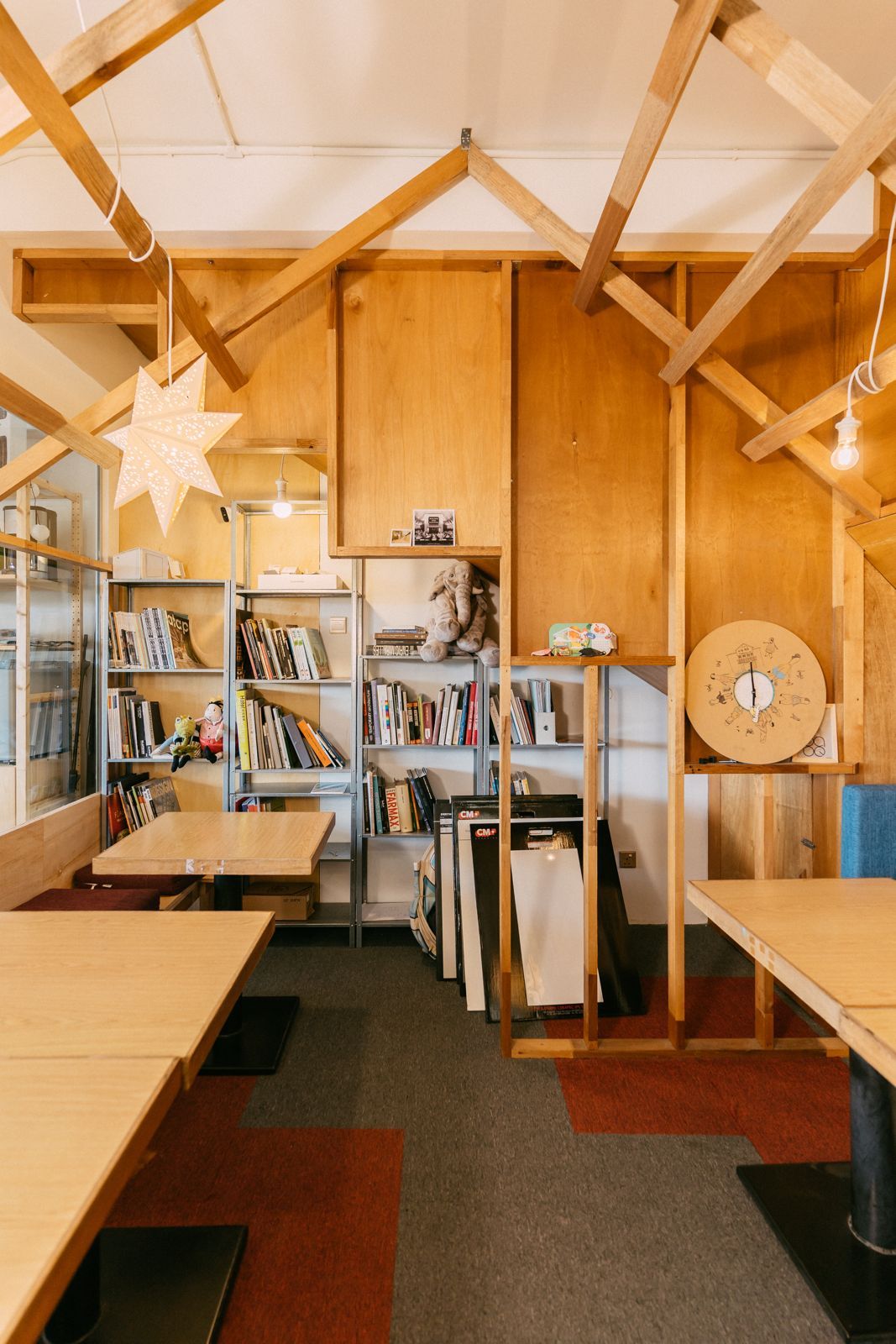 Interior view of the collaborative workspace highlighting the exposed timber ceiling structure and comprehensive design library that supports the studio's research-based practice
