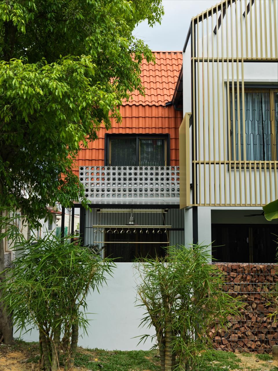 Street elevation of a residential project featuring clay tile roofing, perforated concrete blocks, and timber screening—exemplifying the studio’s contextual approach to Malaysian urban housing