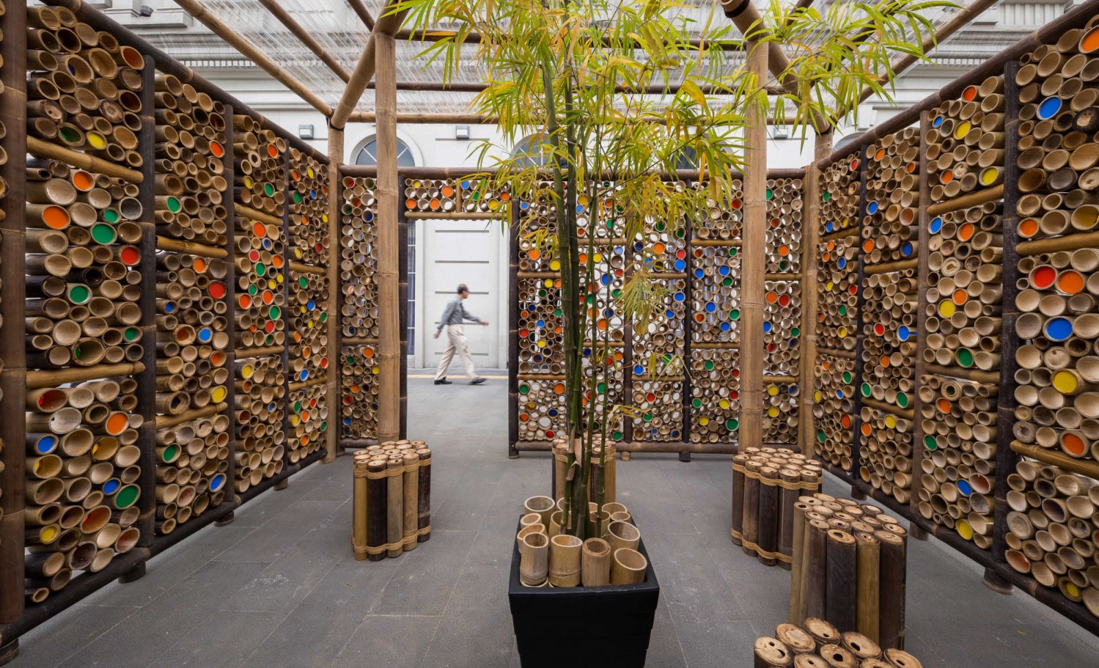 Interior installation using bamboo tubes with colourful end caps, creating an immersive spatial experience, exemplifying EJA’s exploration of local materials and their potential for creating engaging community spaces and cultural installations