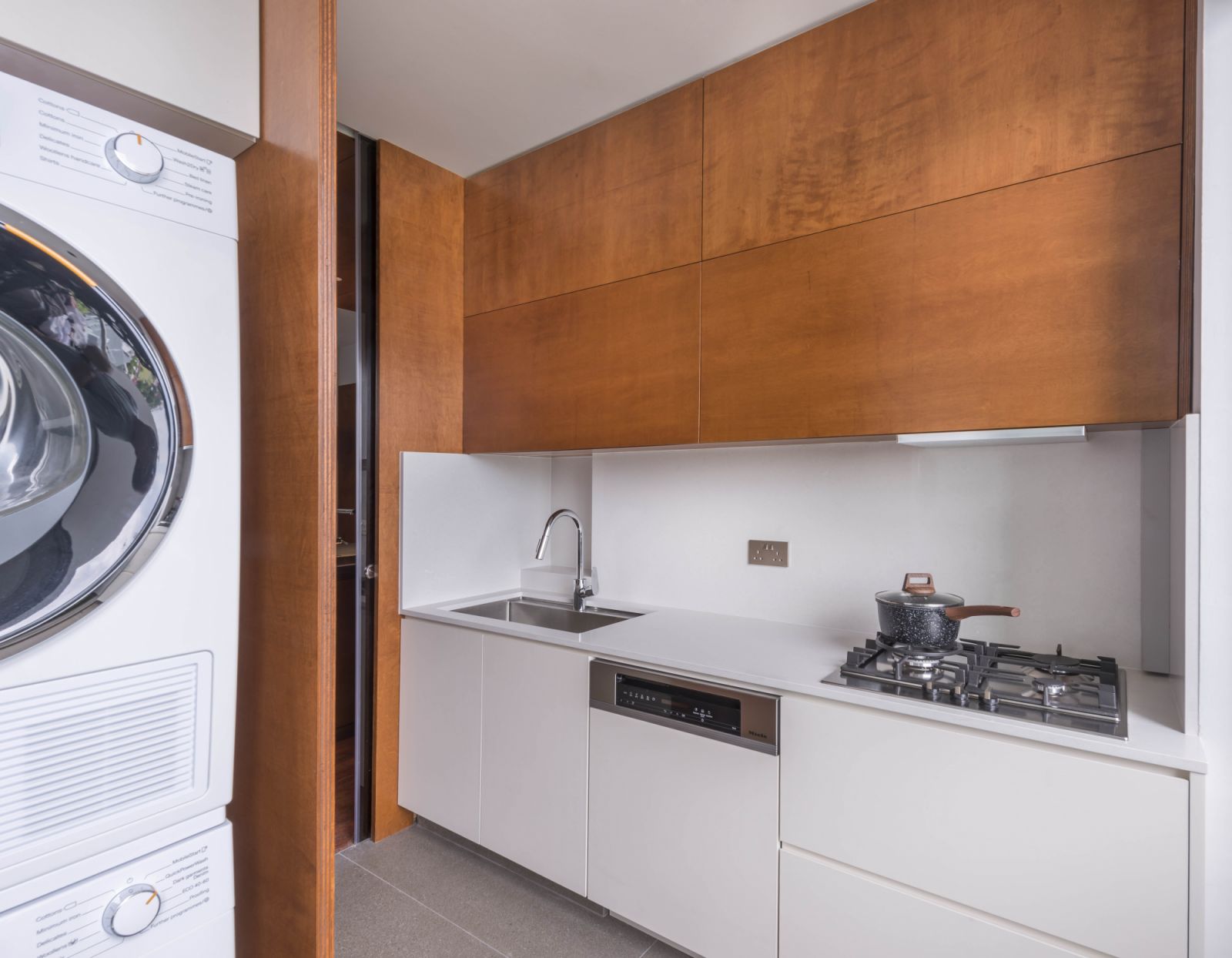 The home is a remarkable juxtaposition of neutral hues augmented by the extensive application of timber fittings in rich tones