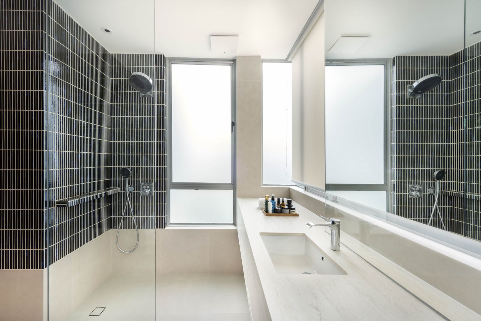 Vertically laid-out green subway tiles bring a modern slant and invigorating colour to the bathroom