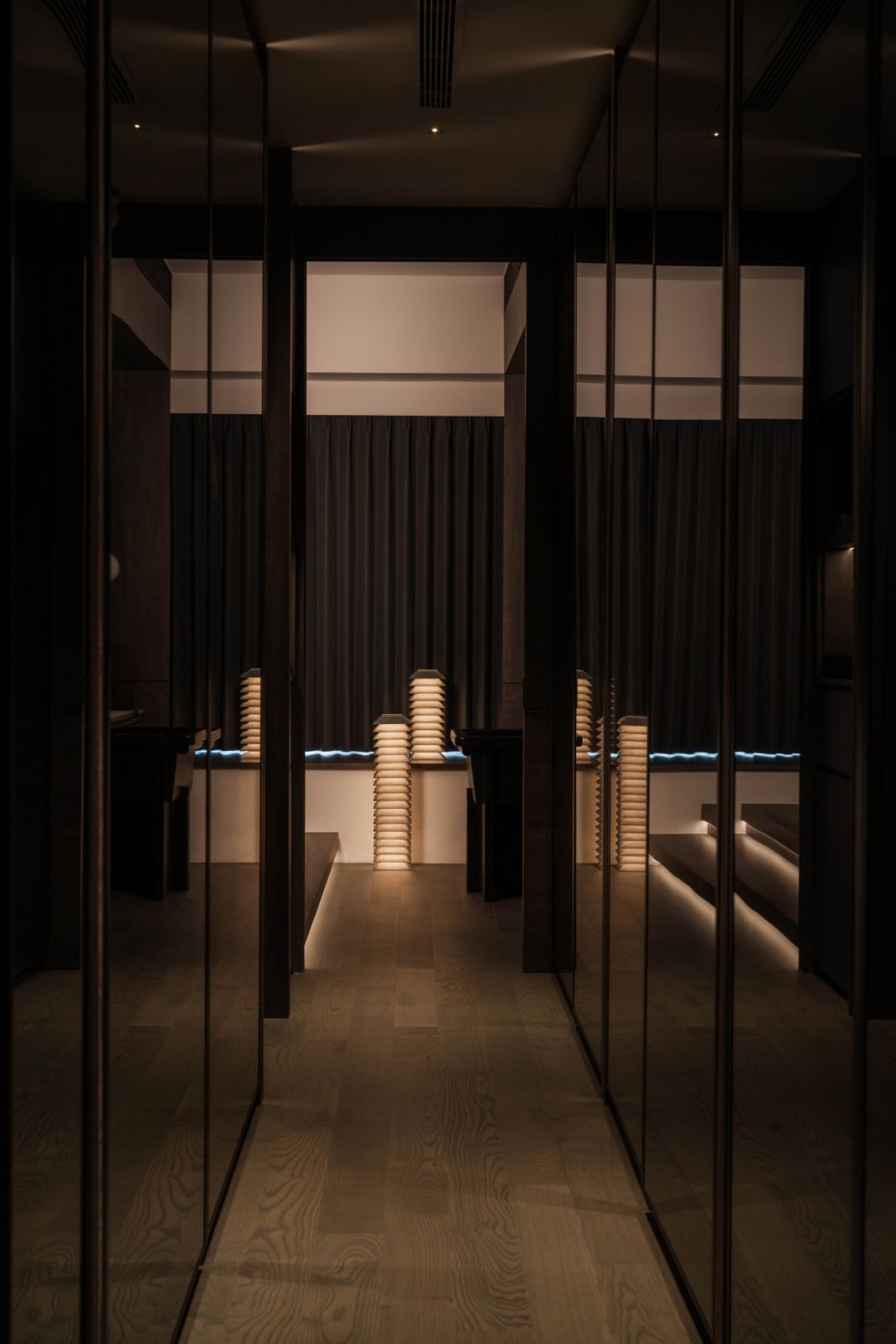 Mario Tsai’s Pagoda lights add visual interest to the mirrored surfaces in this space