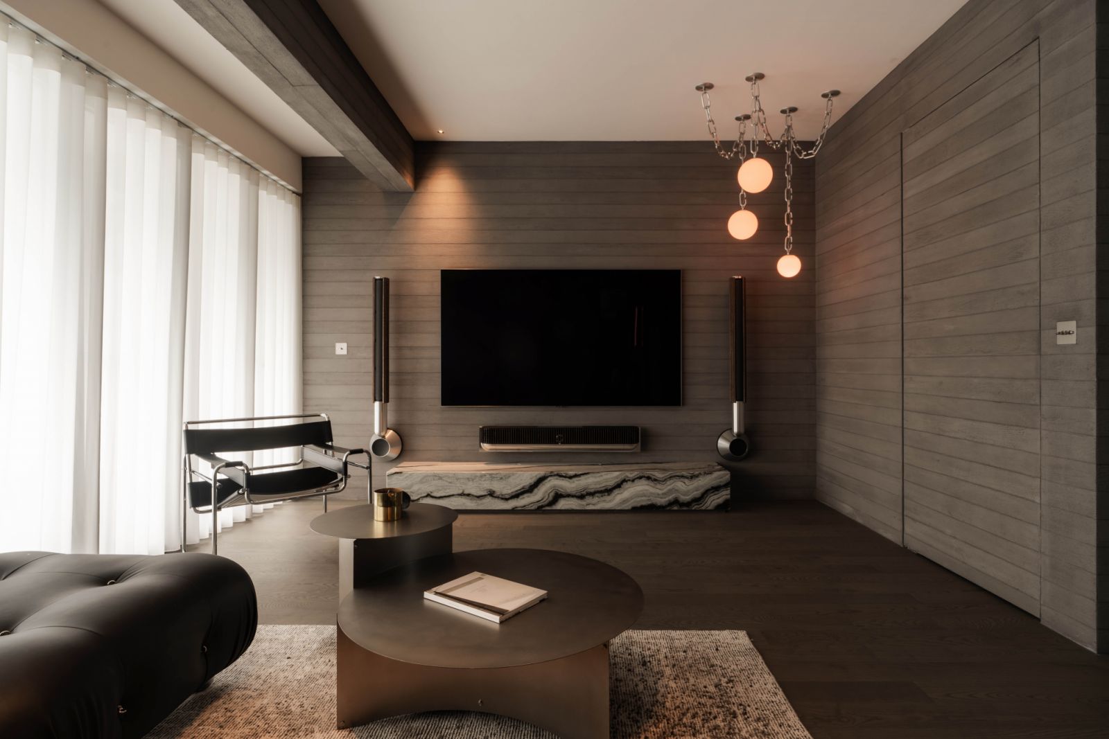 Inspired by Mies van der Rohe’s Barcelona Pavilion, the stylish living room features iconic pieces by architectural greats such as the Knoll Wassily chair by Marcel Breuer, alongside statement designs by local talents, such as the Boba Chain pendant