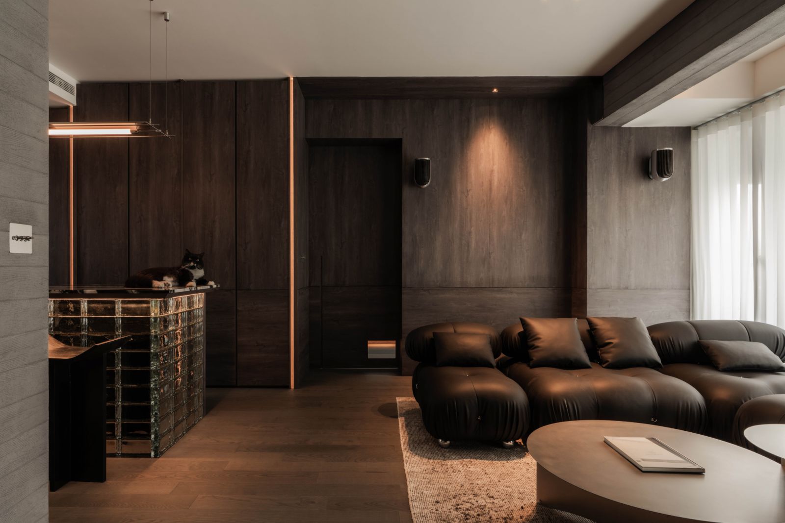 The monochromatic living and dining areas showcase layered textures
