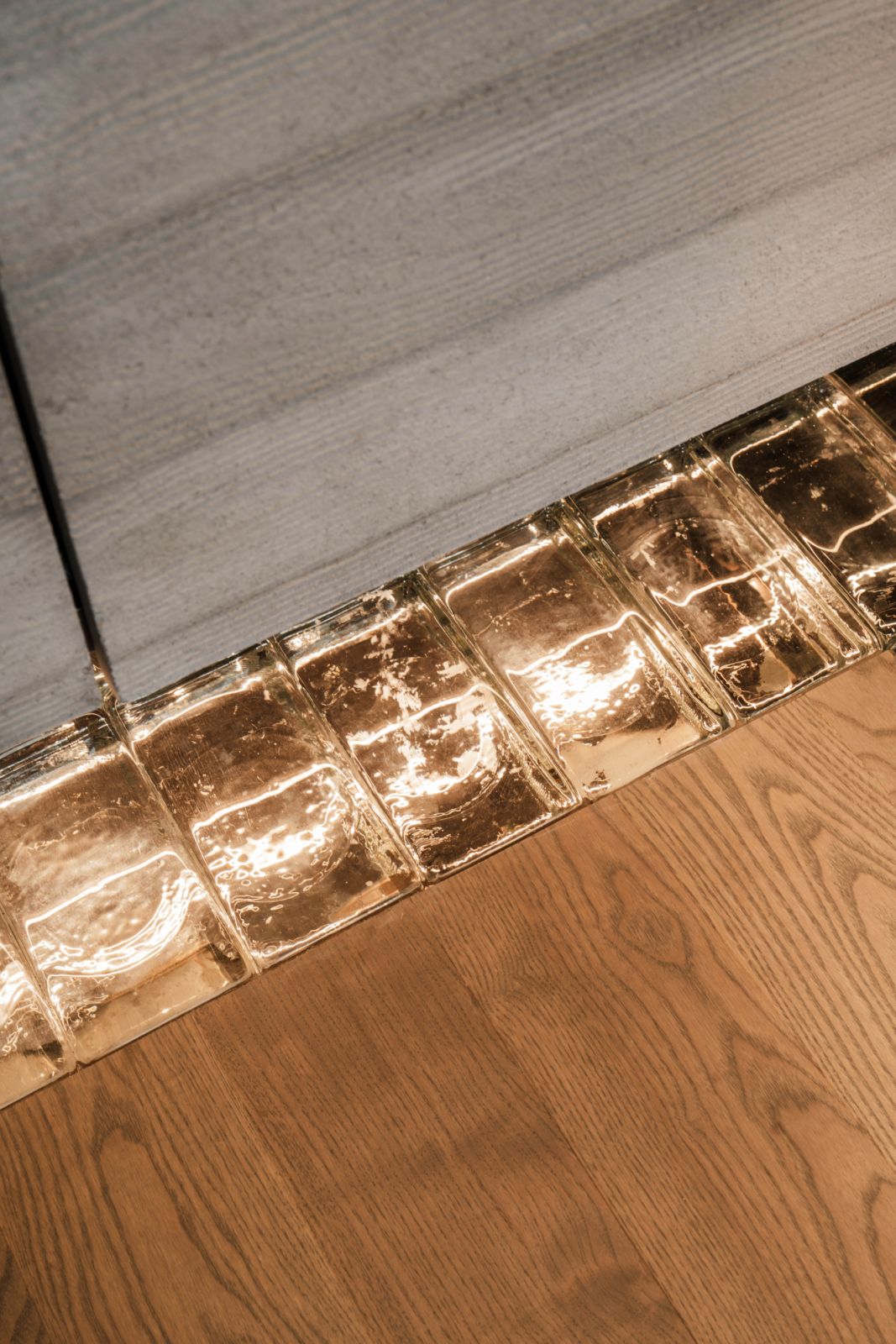 Subtly lit glass bricks from Ornate+ provide a gentle transition between two timber finishes