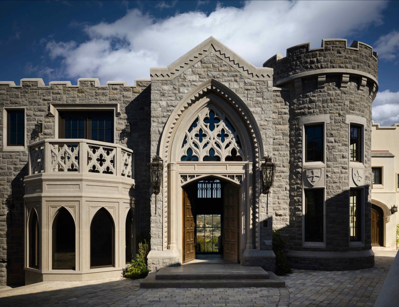 The Gothic-inspired façade features cleft face cladding and architectural elements reminiscent of majestic European castles