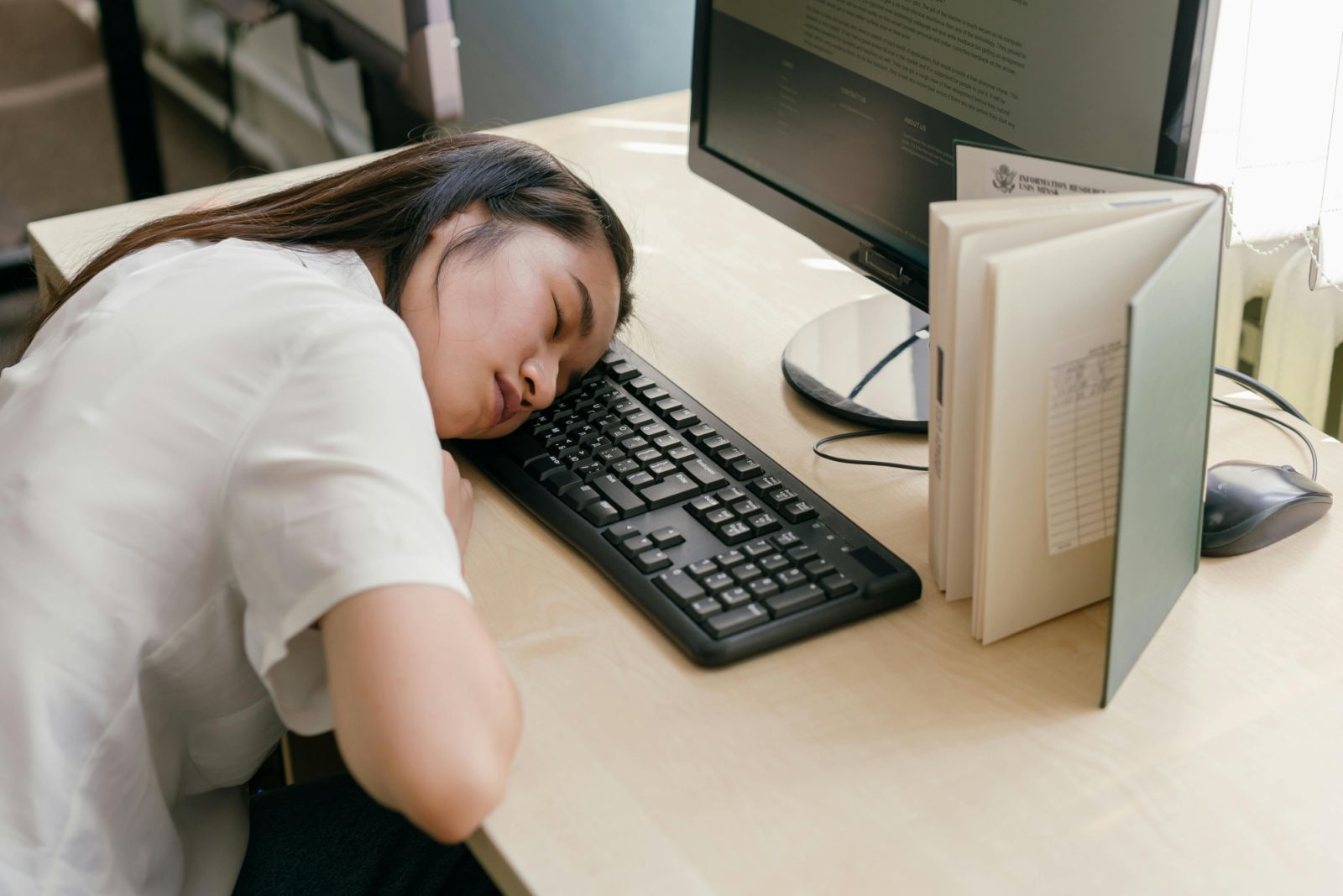 Vietnamese office worker napping at a desk during the midday ngu trua rest break
