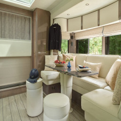 White buffalo leather seating and soft grey quarter-cut ash veneer create a refined living space in the horsebox that feels more like a private club than mobile accommodation