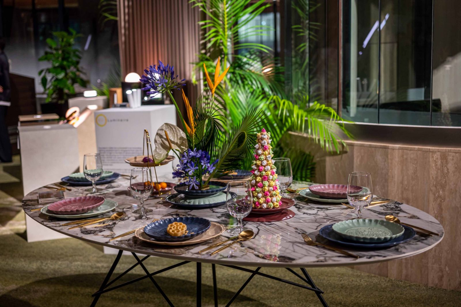 A tablescape on Space furniture dining table featuring Luzerne’s Dynasty collection and Fiore Dorato floral arrangement
