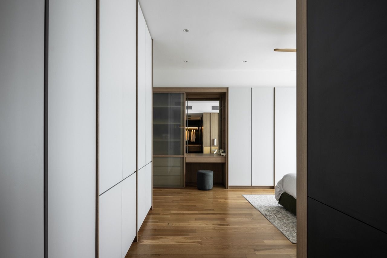 Glass sliding doors maintain a visual connection between the bedroom and the walk-in wardrobe areas