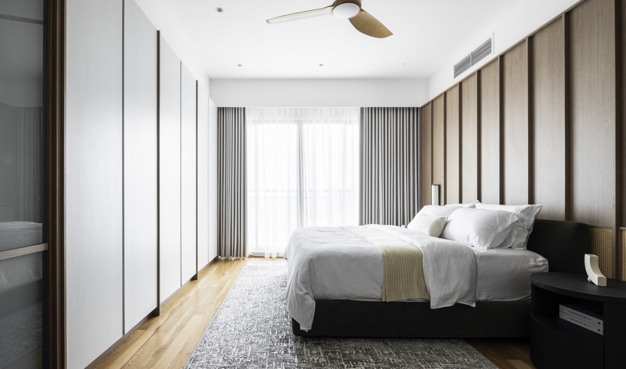 The Japandi-themed master bedroom showcases natural materials like wood and cane