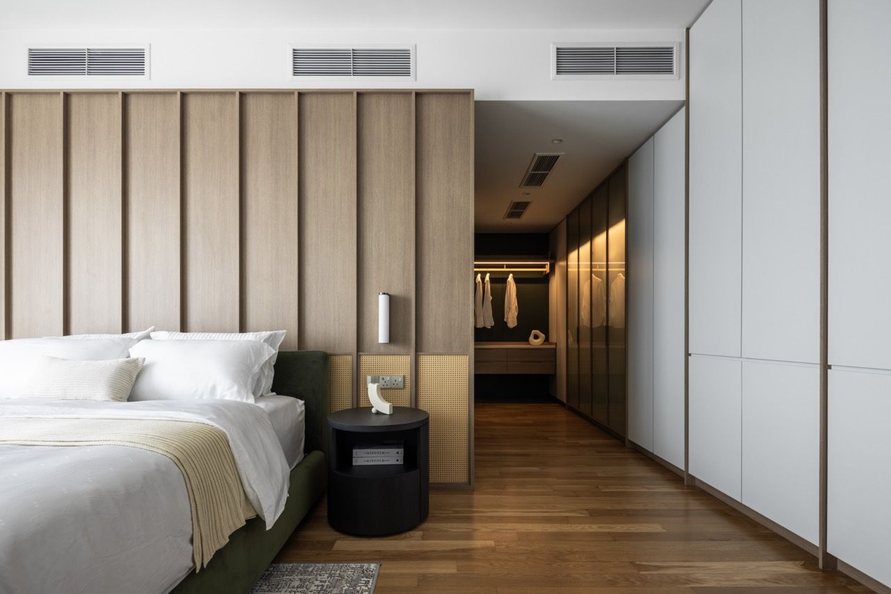 Vertical timber paneling creates rhythm across the walls while a black circular side table adds contrast