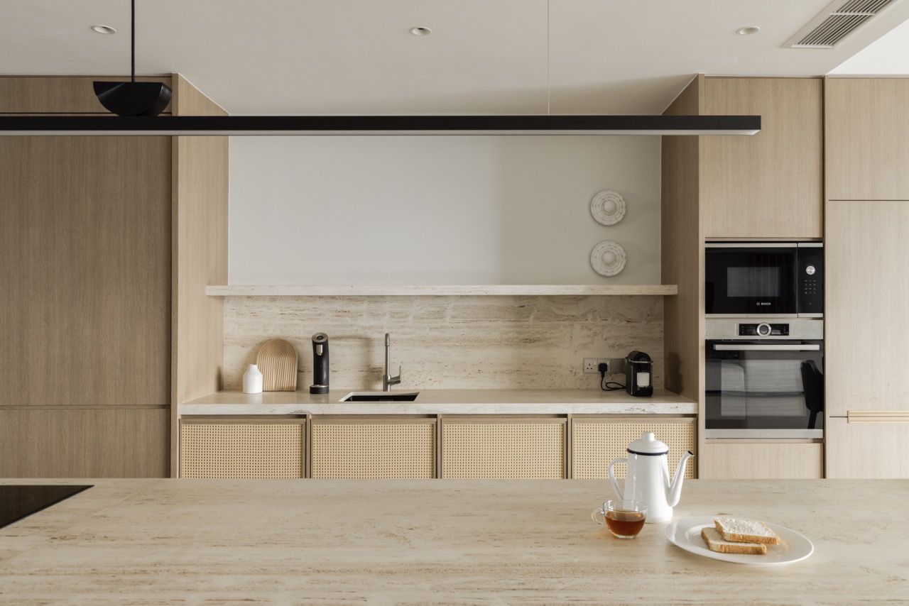 The interplay of smooth travertine and textured timber creates visual rhythm across the surfaces.
