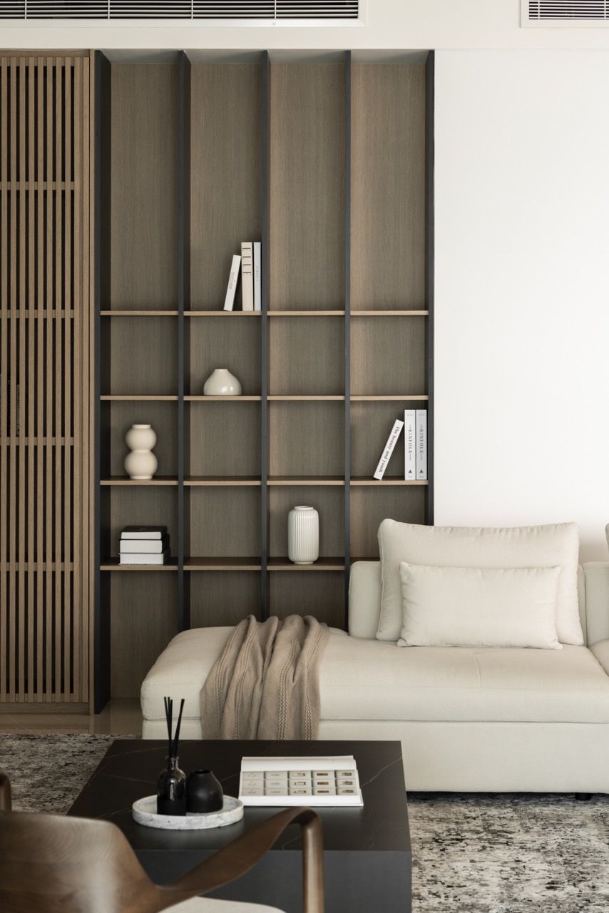 Cream sectional sofa and dark timber coffee table create a comfortable gathering space with built-in storage as a backdrop