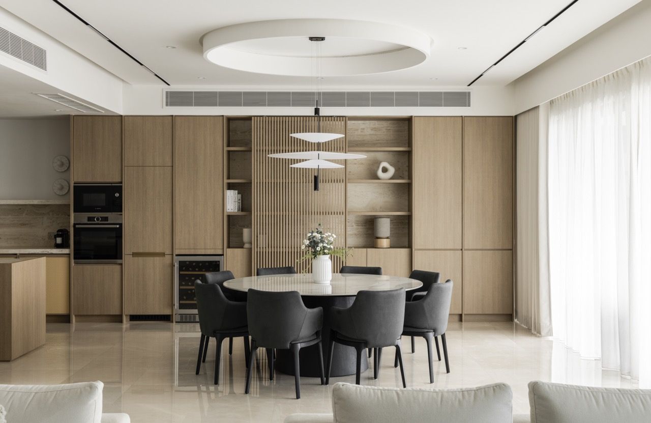 The curved ceiling detail and tiered pendant lighting create architectural interest above the dining table