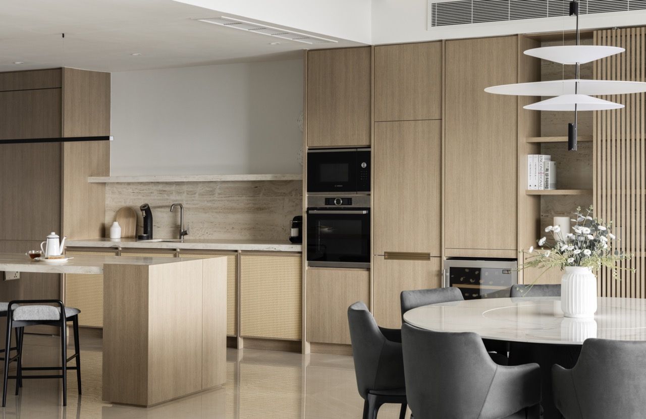 The open-plan design connects kitchen, dining, and living areas while maintaining distinct functional zones with consistent material language