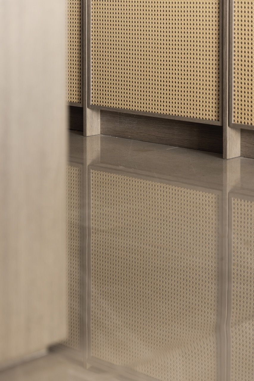 Travertine countertops and timber cabinetry create a workspace that balances function with visual appeal