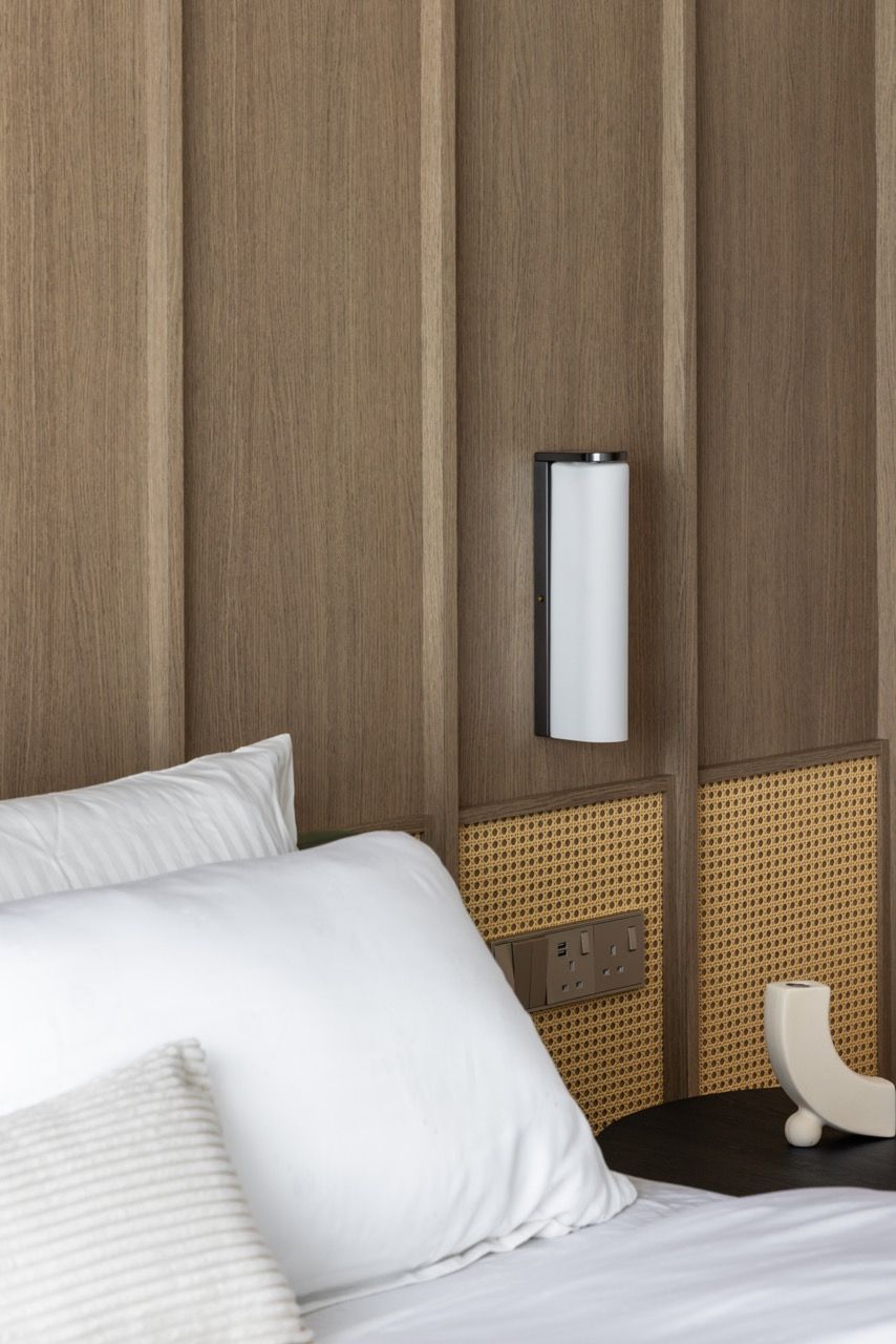 Natural rattan detailing adds warmth and prevents the neutral scheme from feeling too minimal