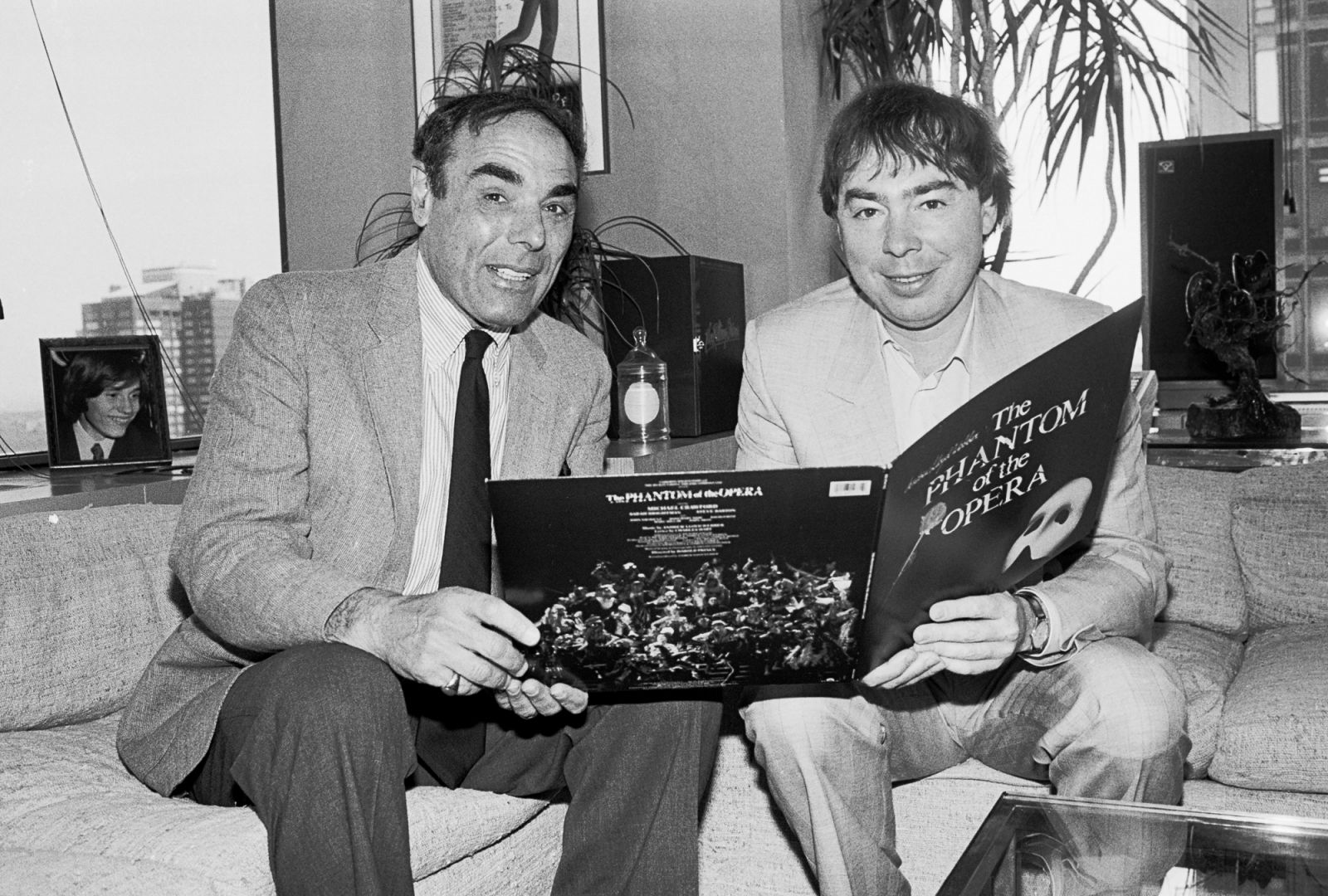 Portrait of President & CEO of Polygram Records Dick Asher (born Martin Richard Asher, 1932 - 2024) (left) and English composer Andrew Lloyd Webber as they hold a cast recording album of the latter's 'Phantom of the Opera' musical at Polygram Records, New York, New York, May 13, 1987. (Photo by Gary Gershoff/Getty Images)