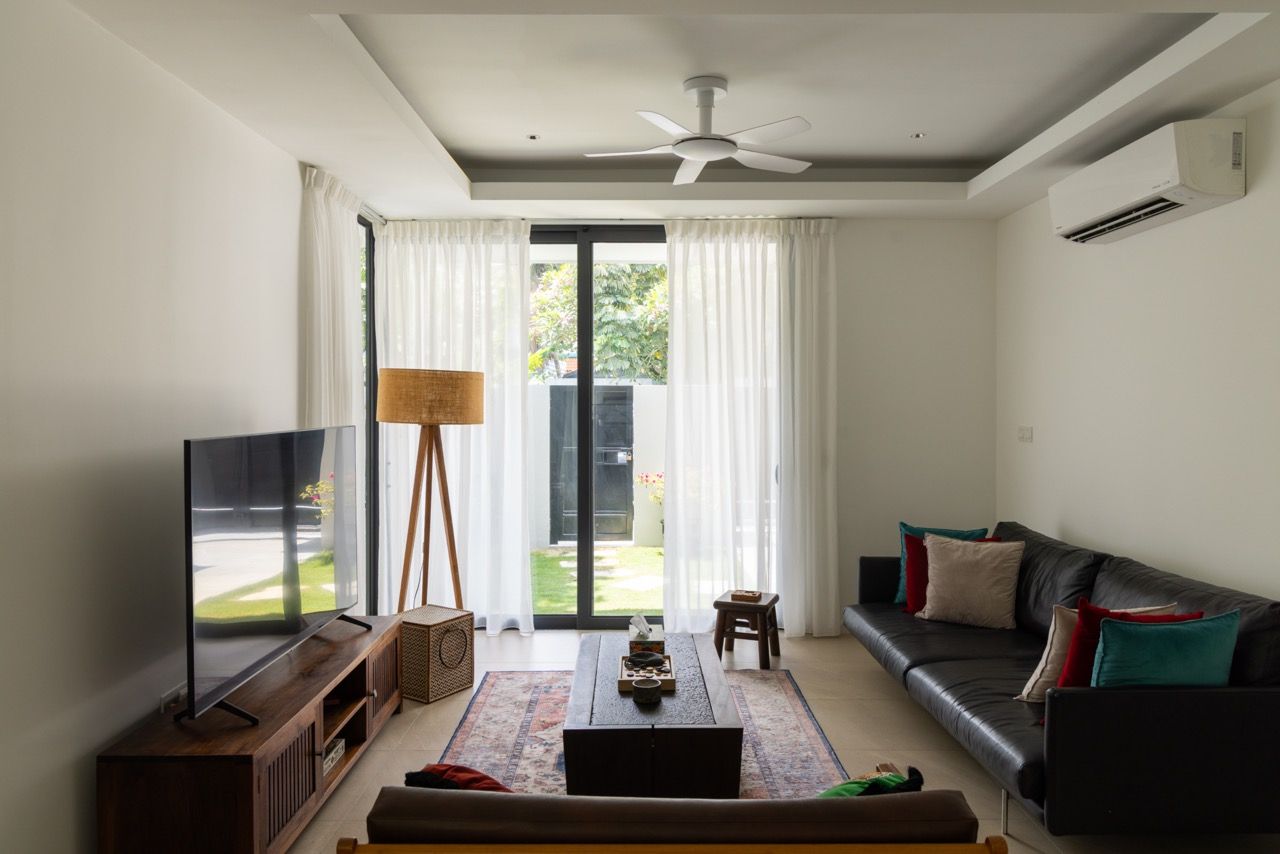 The family room offers a more intimate scale for relaxation, featuring views of the garden and contemporary furnishings that complement the architectural interventions.