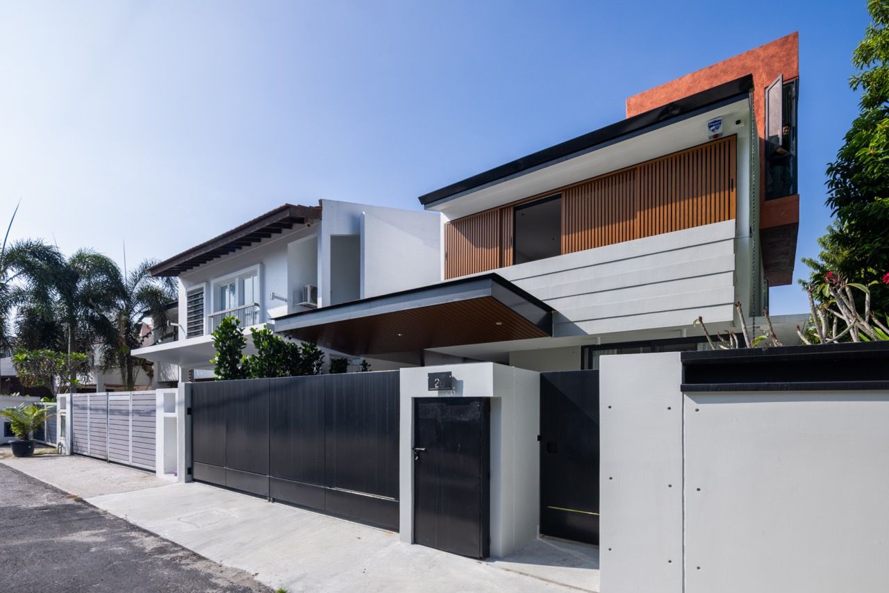 The street-facing elevation shows the complete transformation of the 40-year-old terrace house, with the custom-designed main gate and contemporary façade treatment contrasting with neighbouring traditional properties