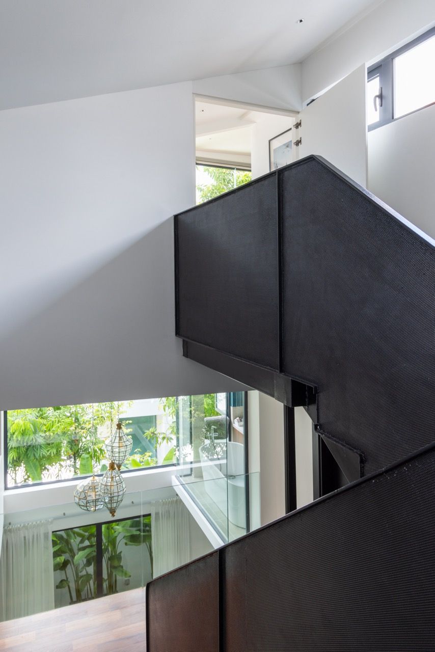 The perforated steel staircase balustrade provides safety whilst maintaining visual connections between levels, part of the custom detailing that extends throughout the house