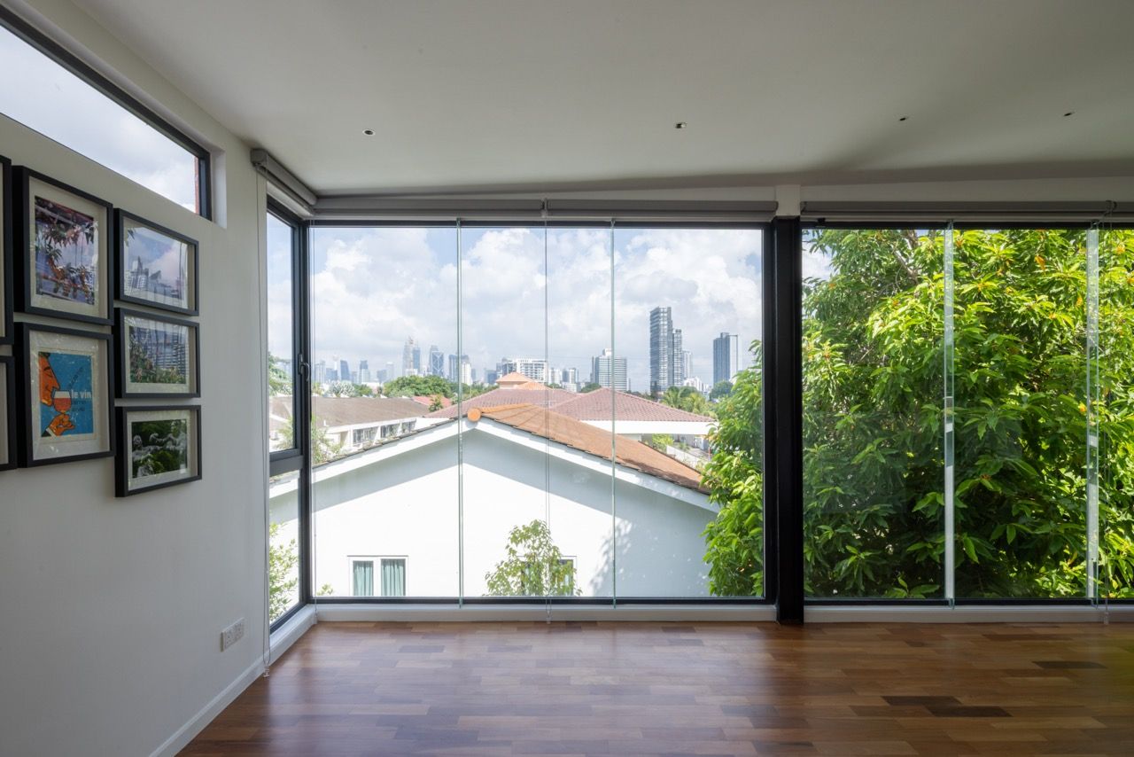 The third-floor mezzanine space serves as the home office and evening retreat where the family gets to enjoy occasional drinks while enjoying the night view, with panoramic windows facing the Kuala Lumpur city skyline