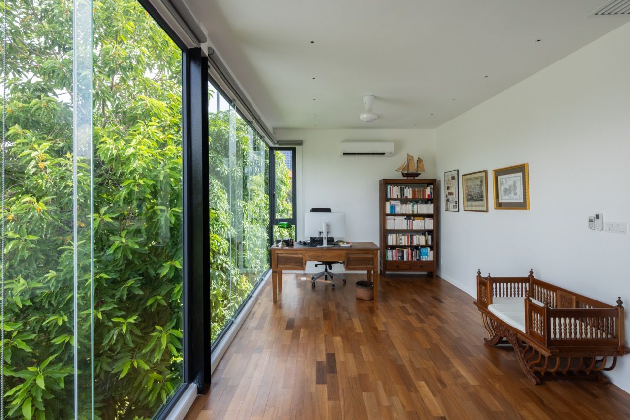 A secondary living space on the upper level features built-in timber furniture and expansive windows to the side garden, taking advantage of the end-lot's natural light benefits