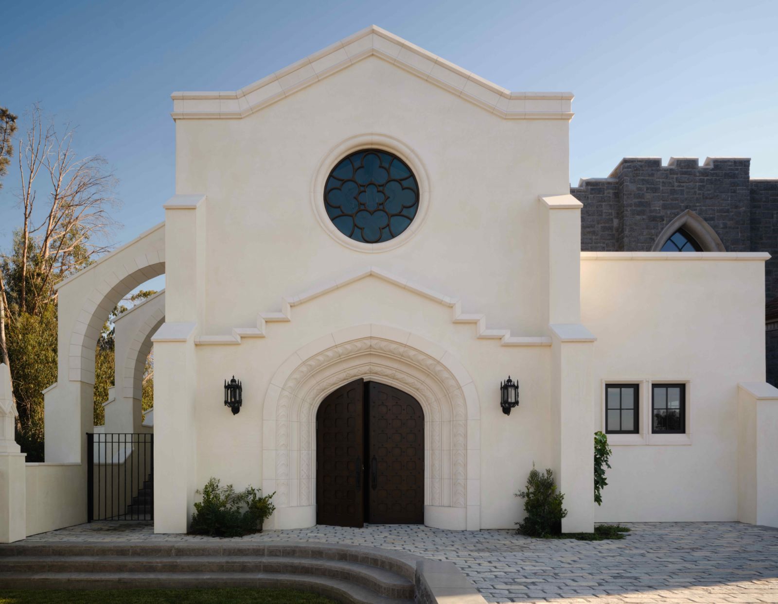 A white chapel with a confessional booth and refurbished chapel doors