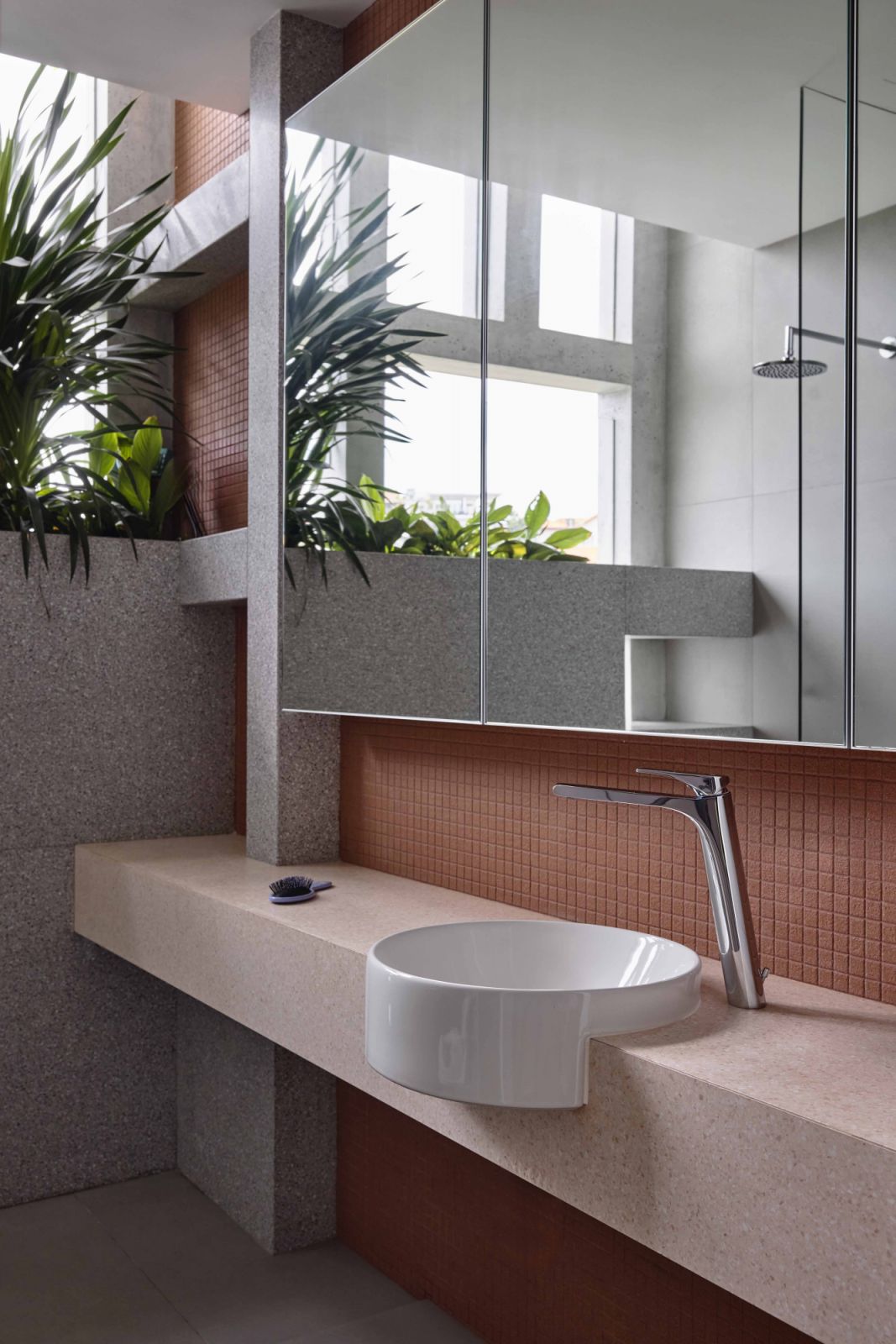 The impeccable craftsmanship of the circular sink, which appears to carve into the bathroom counter, is a subtle highlight of this bathroom